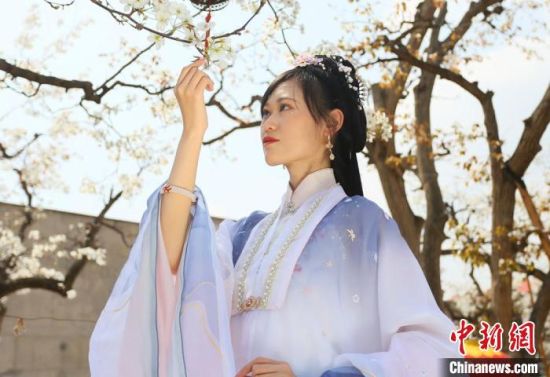 圖為蘭州青年身穿漢服在百年梨園賞景?！「哒?攝