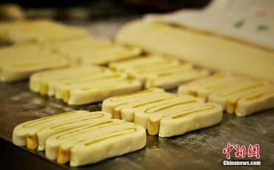 圖為面劑被涂上胡麻油，切成條狀用作月餅的花型制作。張文 攝