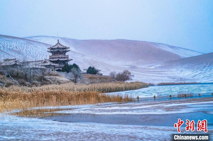 2021年11月28日，雪落鳴沙山月牙泉景區(qū)。　王斌銀 攝