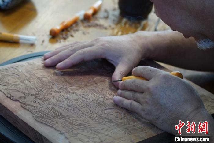 圖為徐晉林湊近木板，近距離制作雕版畫。　九美旦增 　攝
