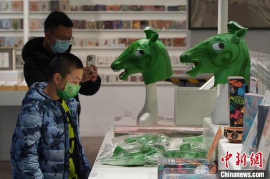 圖為“神馬來了”銅奔馬頭套吸引參觀者駐足?！【琶赖┰?攝