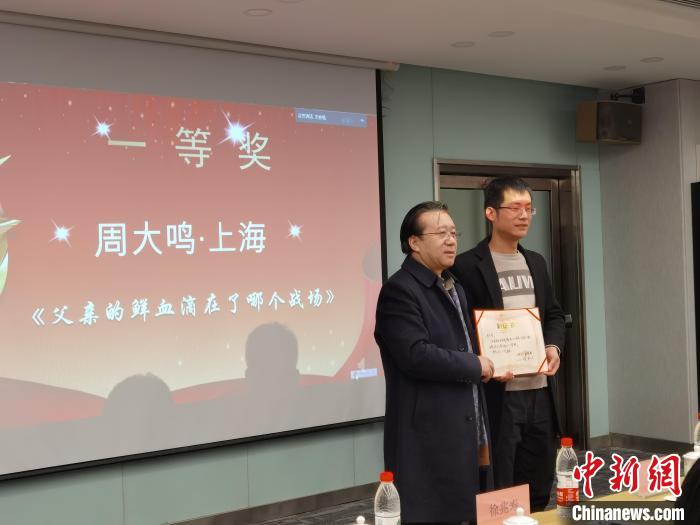 圖為作家、西北師范大學(xué)新聞與傳媒學(xué)院院長徐兆壽頒發(fā)一等獎證書，代領(lǐng)獎?wù)呱吓_領(lǐng)獎?！钅?攝