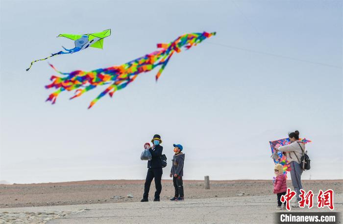 圖為孩童在父母的陪伴下放風(fēng)箏。　王斌銀 攝