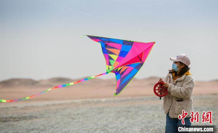 圖為市民正在陽關(guān)景區(qū)放風(fēng)箏。　王斌銀 攝