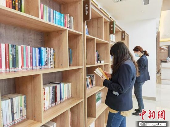 圖為在甘肅公航旅建設集團有限公司的職工書屋，職工挑選書籍?！⌒煅?攝