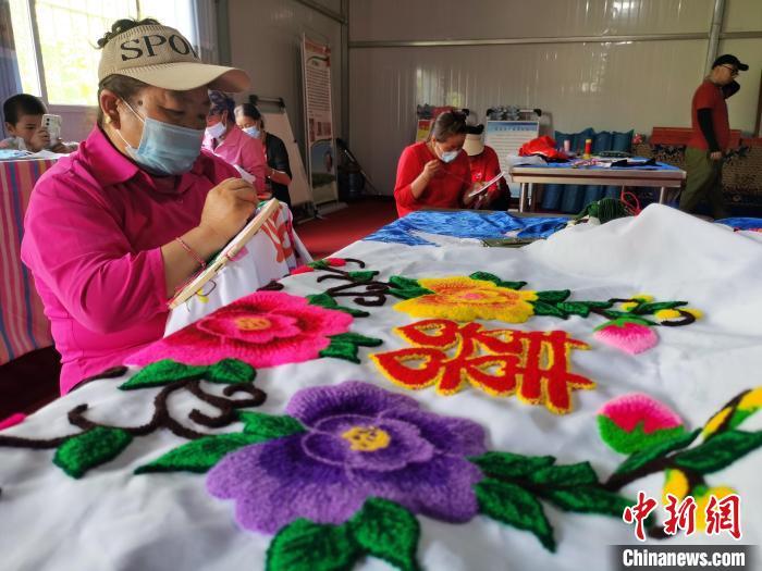 圖為婦女制作青繡?！?zhí)砀?攝
