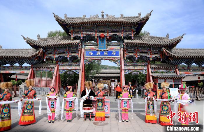 圖為身穿土族服飾的工作人員迎接訪客?！⊙Φ?攝