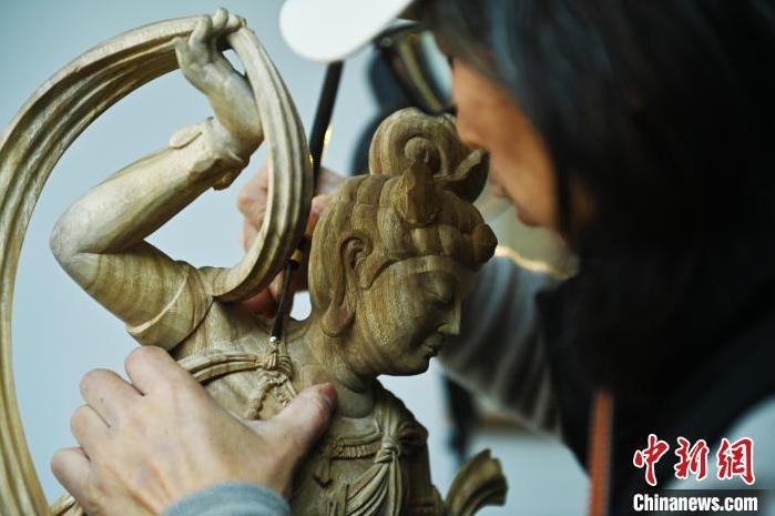 圖為季茂杰進(jìn)行敦煌元素的木雕創(chuàng)作。李亞龍 攝</p>
<p>