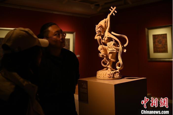 圖為季茂杰向參觀(guān)者介紹自己創(chuàng)作敦煌木雕的過(guò)程。李亞龍 攝</p>
<p>