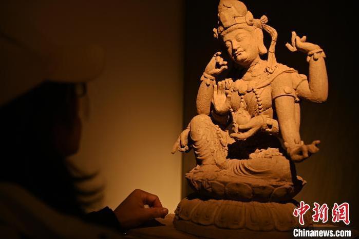 圖為季茂杰觀(guān)察自己創(chuàng)作的敦煌木雕。李亞龍 攝