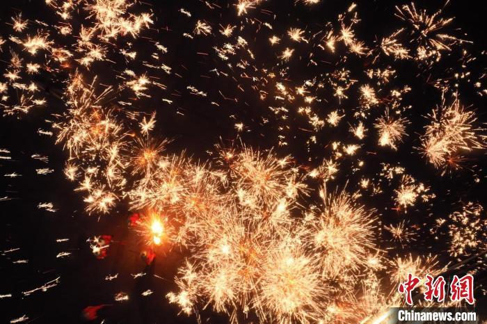 灼熱的鐵水在空中迸散。在空中形成“鐵花火雨”的景象，似天女散花，似群星漫天，如夢如幻，美不勝收。侯奇志 攝</p>
<p>