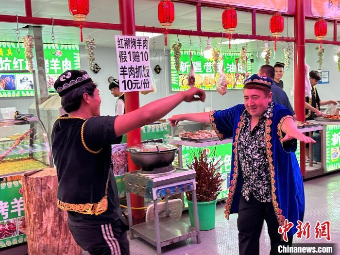 圖為餐飲經(jīng)營者在“西涼不夜城”跳起舞蹈引客?！〈魑牟?攝</p><p>