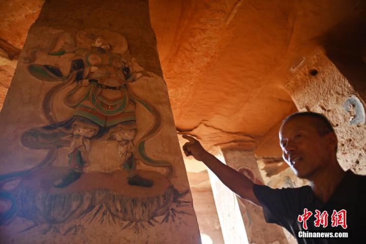 7月15日，甘肅省平?jīng)鍪袥艽h百里石窟長廊羅漢洞石窟內(nèi)，該窟文保員郭建平介紹窟內(nèi)石刻彩繪壁畫。郭建平家中三代人曾自發(fā)保護(hù)羅漢洞石窟。羅漢洞石窟遺存40余個(gè)窟龕，以北魏至清代風(fēng)格為主。中新社記者 李亞龍 攝</p>
<p>