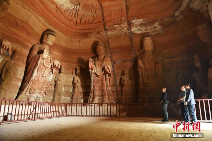 7月15日，游人參觀甘肅省平?jīng)鍪袥艽h百里石窟長廊中的南石窟寺1號(hào)窟。百里石窟長廊位于涇川縣境內(nèi)，由512個(gè)石窟、5眼窟中石井組成，現(xiàn)存王母宮石窟、鳳凰山石窟、南石窟寺、丈八寺石窟、羅漢洞石窟、太山寺石窟等規(guī)模較大的石窟群，還有數(shù)量眾多的小石窟群。南石窟寺開鑿于北魏永平三年，其中1號(hào)窟屬于大型七佛窟，七佛高達(dá)6米。中新社記者 李亞龍 攝