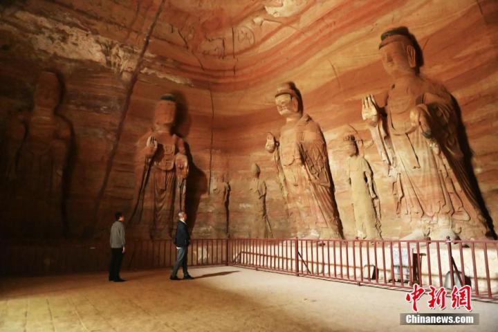 7月15日，游人參觀甘肅省平?jīng)鍪袥艽h百里石窟長廊中的南石窟寺1號(hào)窟。百里石窟長廊位于涇川縣境內(nèi)，由512個(gè)石窟、5眼窟中石井組成，現(xiàn)存王母宮石窟、鳳凰山石窟、南石窟寺、丈八寺石窟、羅漢洞石窟、太山寺石窟等規(guī)模較大的石窟群，還有數(shù)量眾多的小石窟群。南石窟寺開鑿于北魏永平三年，其中1號(hào)窟屬于大型七佛窟，七佛高達(dá)6米。中新社記者 李亞龍 攝