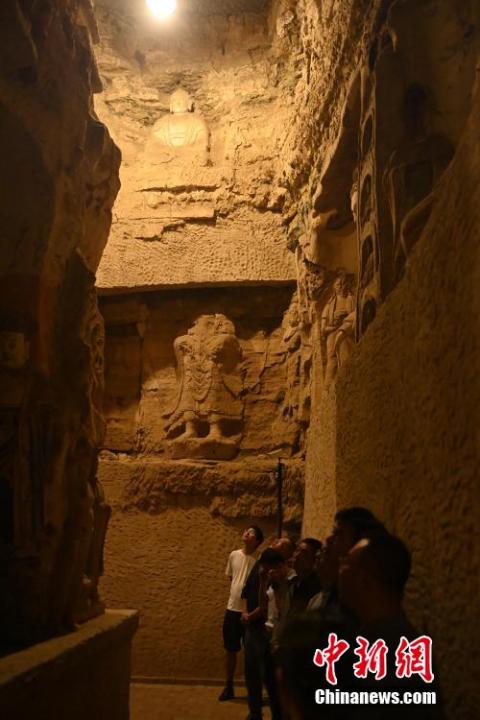 7月15日，游人參觀甘肅省平?jīng)鍪袥艽h百里石窟長廊中的王母宮石窟。百里石窟長廊位于涇川縣境內(nèi)，由512個(gè)石窟、5眼窟中石井組成，現(xiàn)存王母宮石窟、鳳凰山石窟、南石窟寺、丈八寺石窟、羅漢洞石窟、太山寺石窟等規(guī)模較大的石窟群，還有數(shù)量眾多的小石窟群。王母宮石窟又名千佛洞，該窟設(shè)計(jì)宏大，造像生動(dòng)，窟內(nèi)擁有造像數(shù)百尊，是較為珍貴的佛教文化遺存。中新社記者 李亞龍 攝</p>
<p>